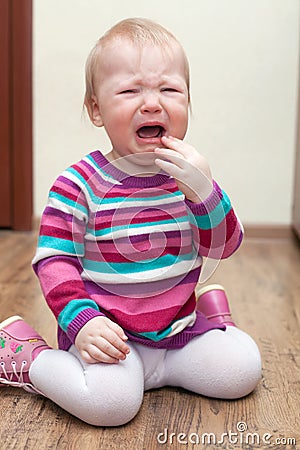 Portrait of crying baby girl on living room at home