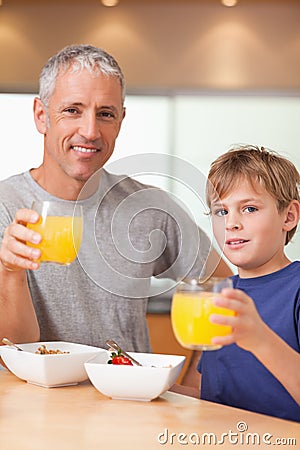 Portrait of a cute boy and his father having breakfast