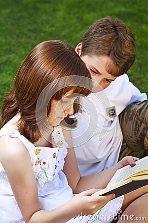 Portrait of cute kids reading books in natural environment