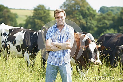 Portrait Of Dairy Farmer In Field With Cattle