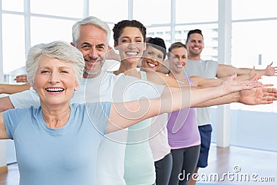 Portrait of fitness class stretching hands in row