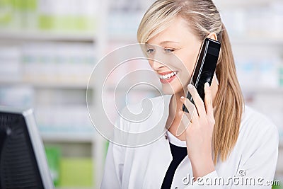 Portrait of a friendly pharmacist on the phone