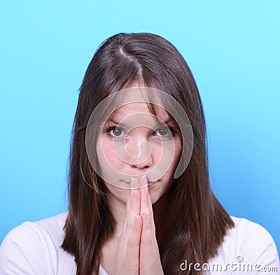 Portrait of girl praying against blue background