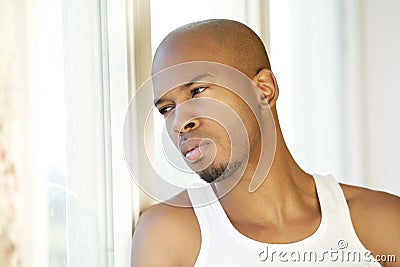 Portrait of a handsome young man looking out of window