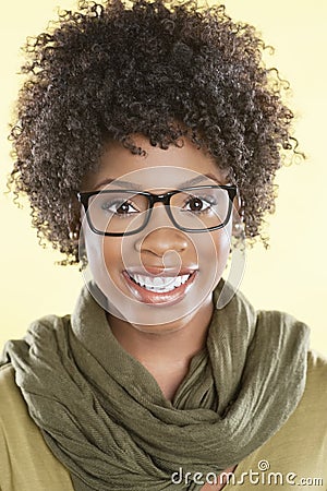 Portrait of a happy African American woman wearing glasses with a stole round her neck over colored background