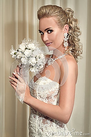 Portrait of the happy beautiful bride holding a bouquet