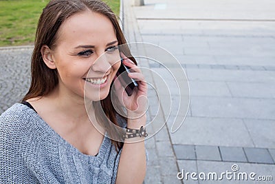 Portrait of a happy fashion woman with mobile phone. In a backgr