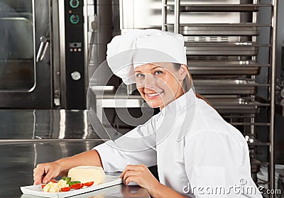 Female Chef With Dish At Counter