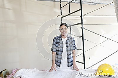 Construction Worker On Building Site Looking At House Plans