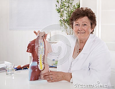 Portrait of happy older senior doctor explaining the human body