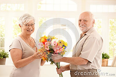 Portrait of happy senior couple with flower