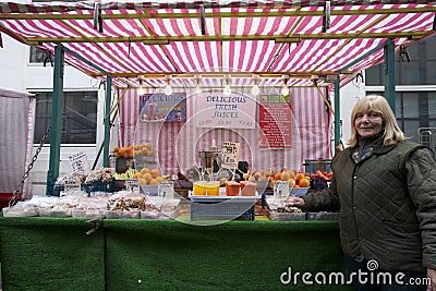 Portrait of a happy senior fruit stall owner standing in market
