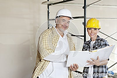 Portrait of happy team of architect with paper documents at construction site