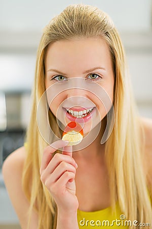 Portrait of happy teenager girl eating chips