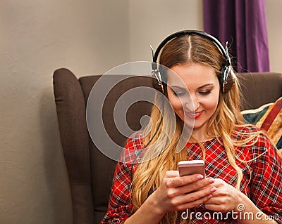 Portrait of happy young woman with mobile phone listening to the