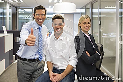 Portrait of joyful business team, man showing thumb up