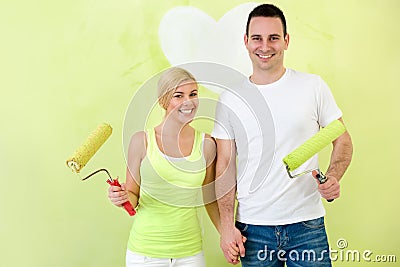 Portrait of love couple with paint rollers