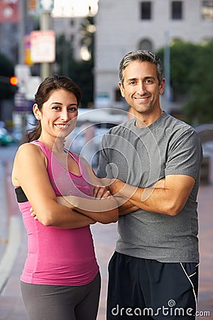 Portrait Of Male And Female Runners On Urban Street
