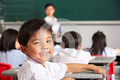 Portrait Of Male Pupil At Desk In Chinese School