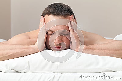 Portrait of man in bed with headache