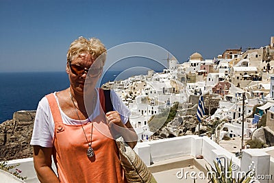 Portrait of a mature tanned woman on sea background and building