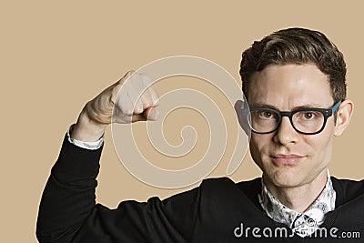 Portrait of a mid adult man flexing muscles over colored background