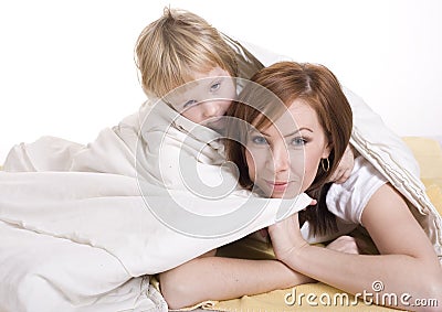 Portrait of mother and daughter laying in bed and smiling