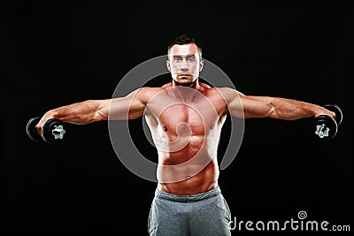 Portrait of a muscular man lifting dumbbells