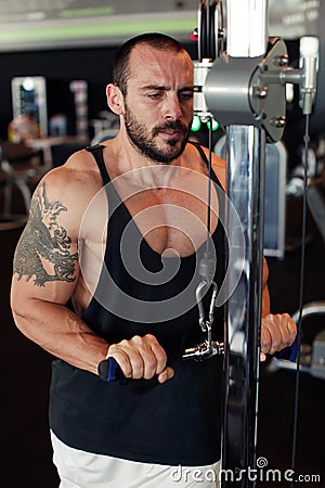 Portrait of muscular man training on special sport equipment