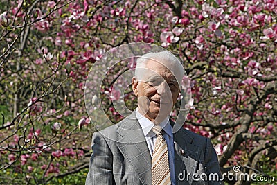 Portrait of old man with magnolia in blossom