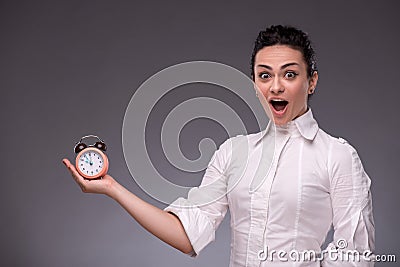 Portrait of pretty girl holding an alarm clock in
