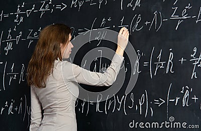 Portrait of a pretty student doing maths on a blackboard