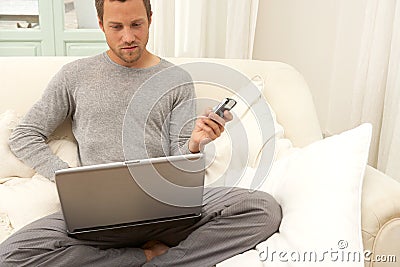 Portrait of professional man with laptop and smart phone at home.