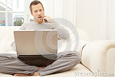 Portrait of professional man with laptop and smart phone at home.