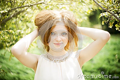 Portrait of redhead girl with blue eyes on nature