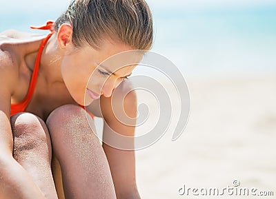 Portrait of relaxed young woman sitting on beach