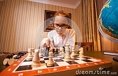 Portrait of smart girl make move on chess board