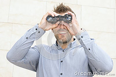 Portrait of smiling businessman looking through the binoculars.