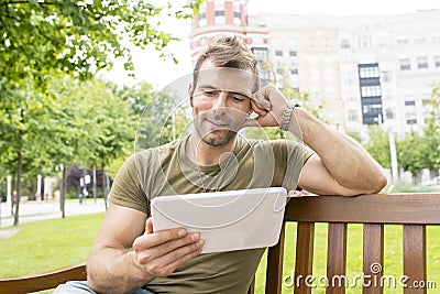 Portrait of smiling casual man looking tablet computer in the st