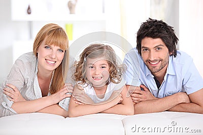 Portrait of a smiling family laid on a bed