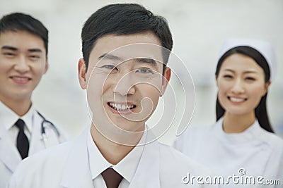 Portrait of Smiling Healthcare workers in China, Two Doctors and Nurse in Hospital, Looking At Camera