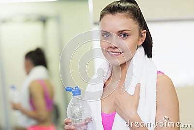 Portrait of a smiling woman with water bottle in gym