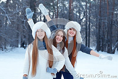 Portrait of three beautiful girls in winter park