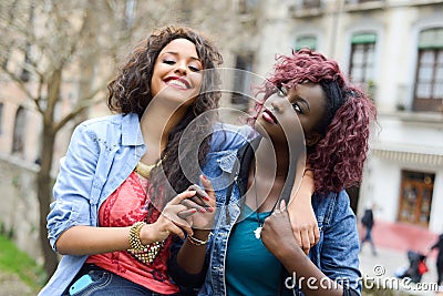 Two beautiful girls in urban backgrund, black and mixed women