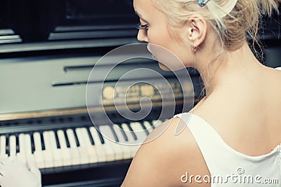 Portrait of woman playing on the retro style piano
