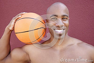 Portrait of a young African American man with basketball on shoulder over colored background