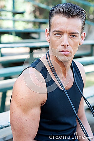 Portrait of a young athletic man with jump rope