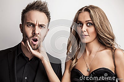 Portrait of young attractive couple posing at studio dressed in black fashionable clothes.