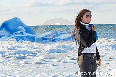 Portrait of young woman with scarf on winter beach