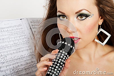 Portrait of a young beautiful woman in black dress singing